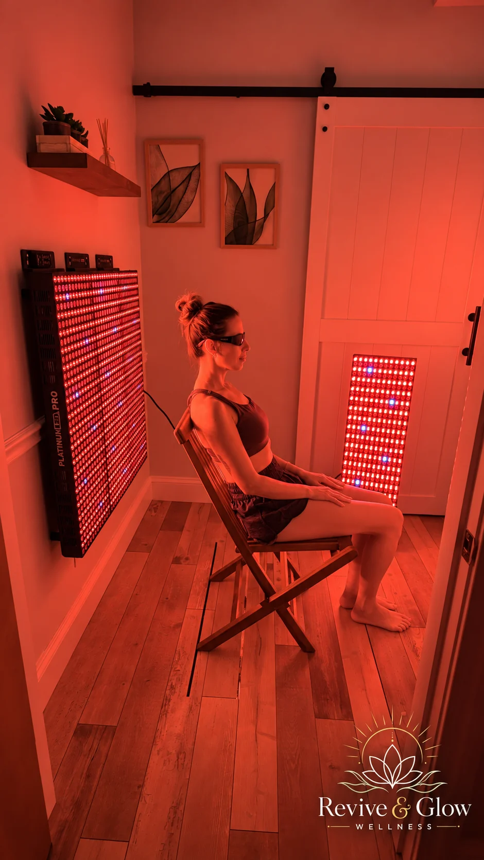 A guest seated between the light therapy panels at Revive & Glow